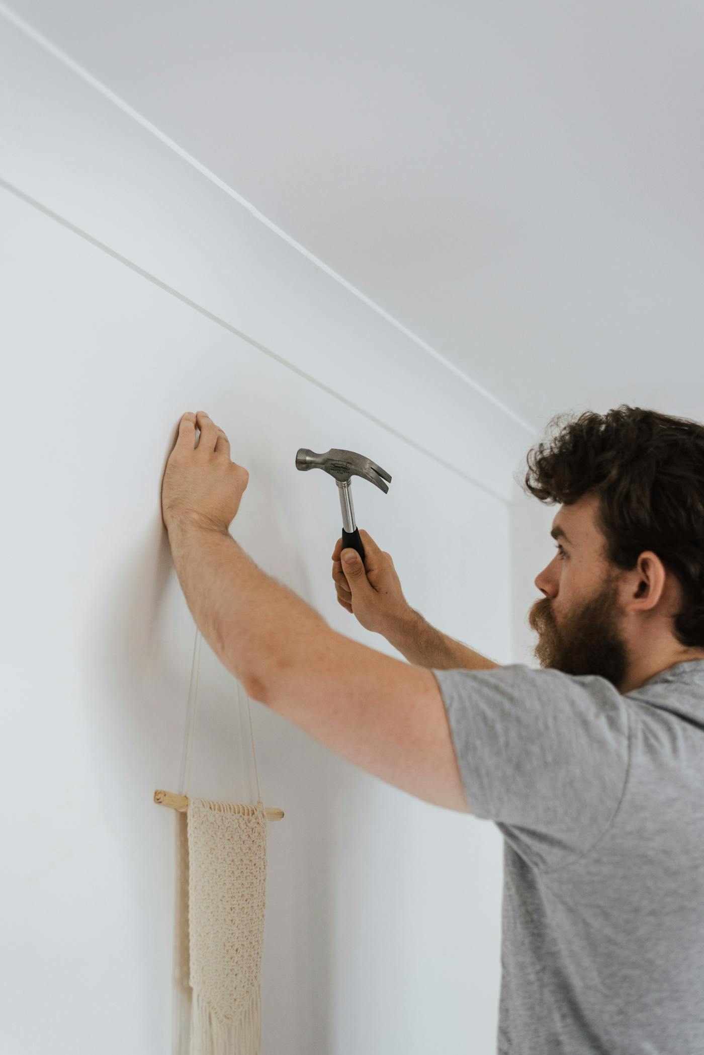 A Austin Handyman Pros pro carefully hanging décor in a customer's home